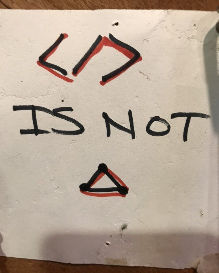 Hand-drawn in marker: a code tag, the words IS NOT, and a triangle.
