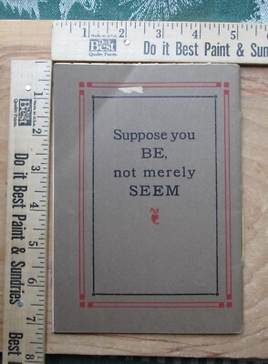 An old printed card on a workbench, reading: Suppose you BE, not merely SEEM.